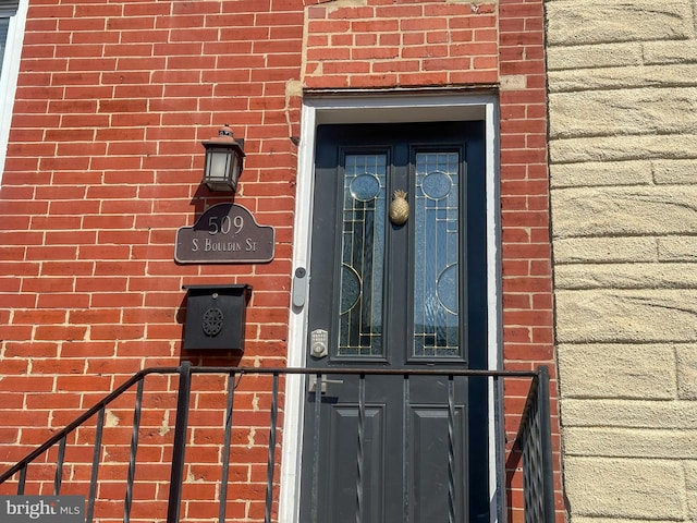 doorway to property with brick siding