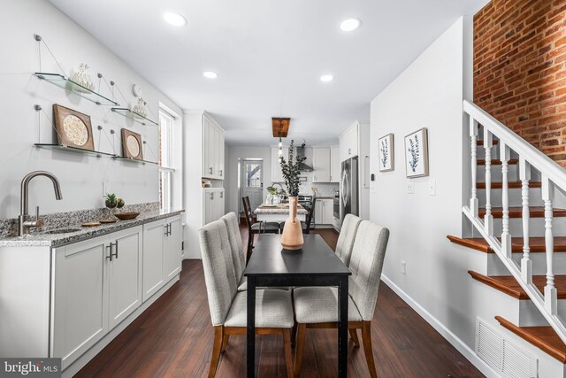 dining room with stairway, dark wood finished floors, wet bar, visible vents, and recessed lighting