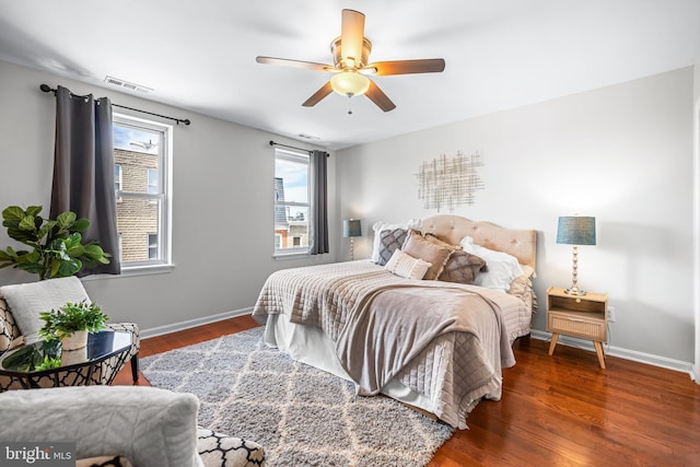 bedroom with ceiling fan, baseboards, wood finished floors, and visible vents