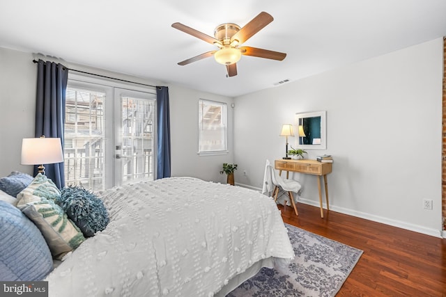 bedroom with wood finished floors, visible vents, baseboards, and multiple windows