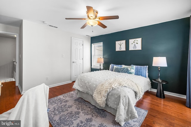 bedroom featuring wood finished floors, visible vents, baseboards, and ceiling fan