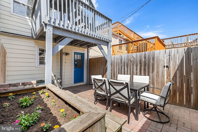 wooden deck with a fenced backyard, a patio area, and outdoor dining area