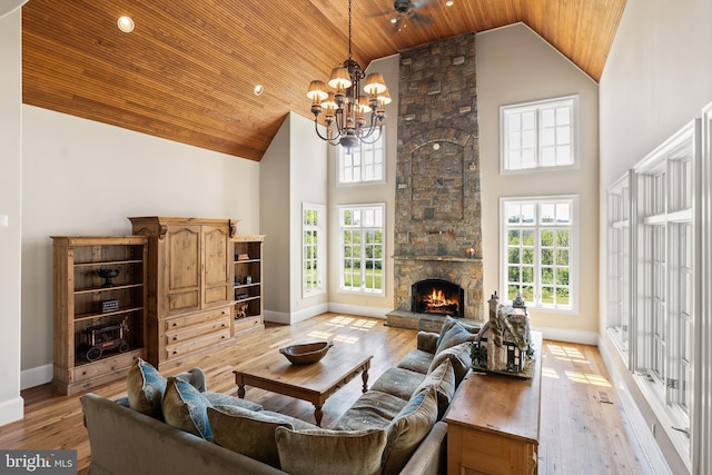 living room with wood ceiling, a notable chandelier, high vaulted ceiling, and a healthy amount of sunlight