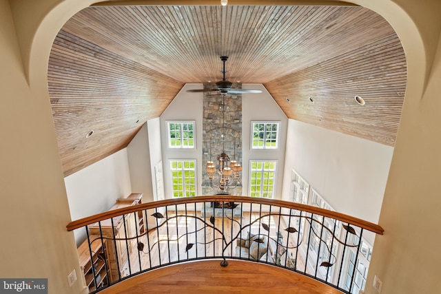staircase with lofted ceiling, wood ceiling, and ceiling fan with notable chandelier