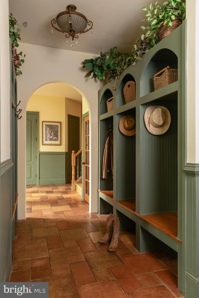 mudroom with wainscoting and arched walkways