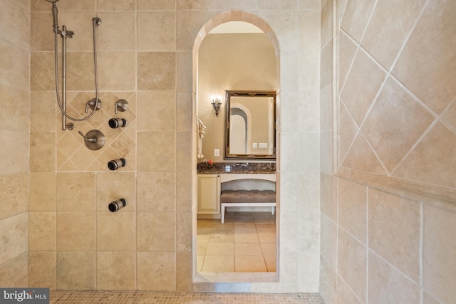 full bathroom featuring a tile shower and vanity