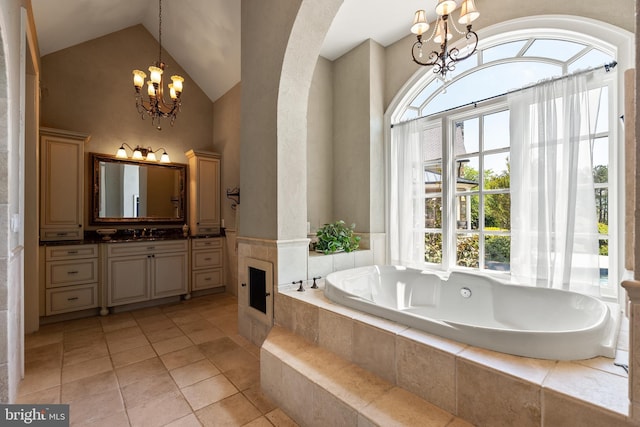 full bathroom with vanity, tile patterned floors, vaulted ceiling, a notable chandelier, and a bath