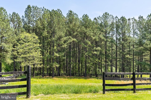 view of home's community featuring a forest view and fence