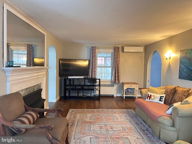 2619 Filbert Ave, Reading, PA 19606 - living area featuring arched walkways, radiator, wood finished floors, an AC wall unit, and a tiled fireplace