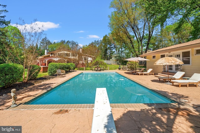 view of pool featuring fence, a diving board, a patio area, and a fenced in pool