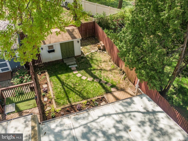 view of yard with an outdoor structure, a shed, and a fenced backyard