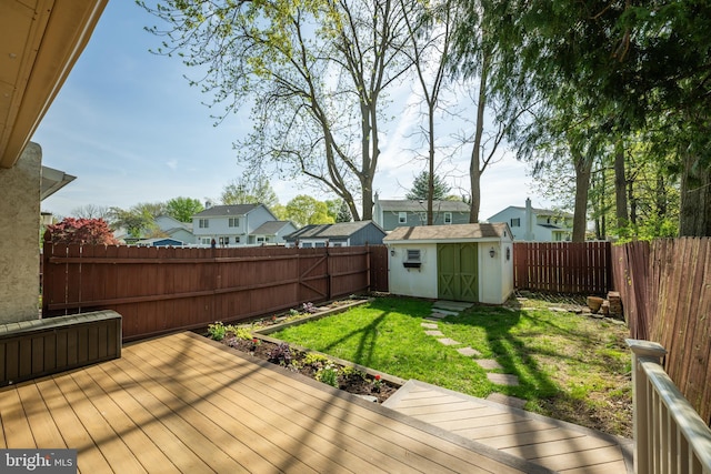 wooden terrace with an outdoor structure, a shed, a residential view, and a fenced backyard