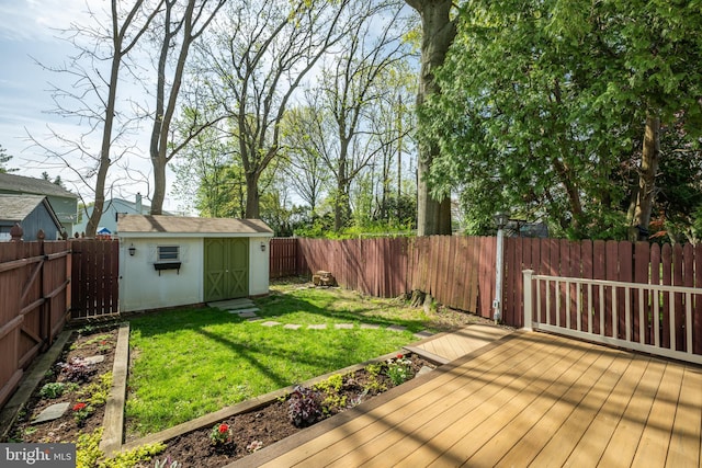 view of yard with an outbuilding, a wooden deck, a shed, and a fenced backyard