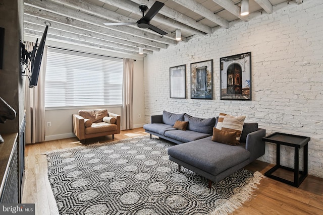 living room with beamed ceiling, wood finished floors, baseboards, and ceiling fan