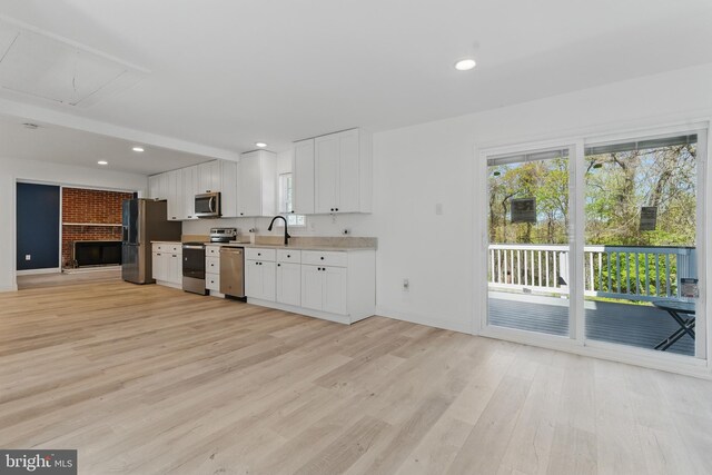 671 Pine Ridge Dr, Front Royal, VA 22630 - kitchen with light countertops, appliances with stainless steel finishes, white cabinets, and light wood-type flooring