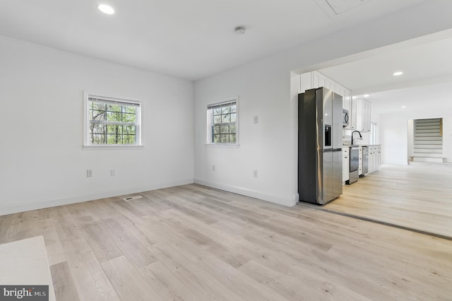 671 Pine Ridge Dr, Front Royal, VA 22630 - unfurnished living room featuring baseboards, a wealth of natural light, and light wood-style floors