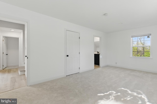 671 Pine Ridge Dr, Front Royal, VA 22630 - unfurnished bedroom with connected bathroom, baseboards, and light colored carpet