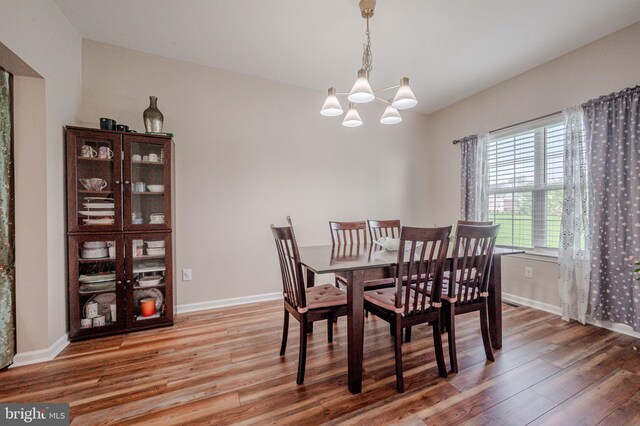dining room featuring baseboards, a chandelier, and light wood-type flooring