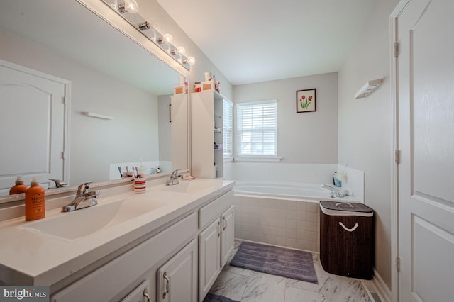 full bathroom featuring marble finish floor, a garden tub, a sink, and double vanity