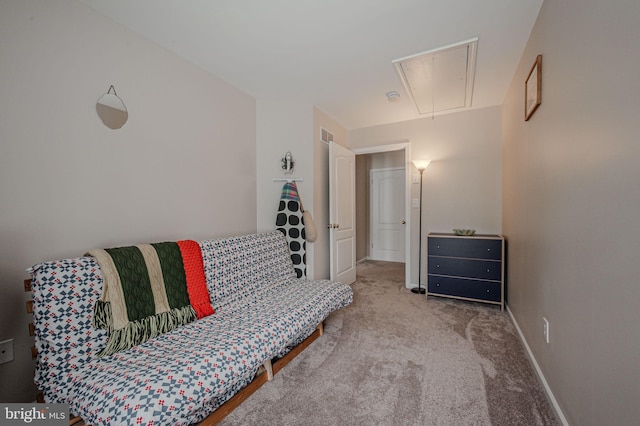 carpeted living area with attic access and baseboards