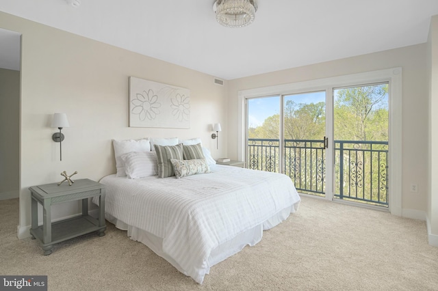 carpeted bedroom with visible vents, baseboards, and access to outside