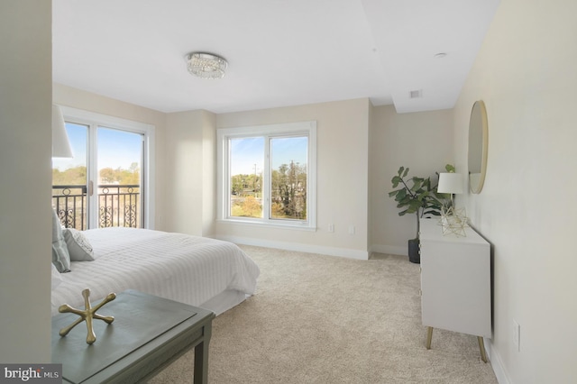 carpeted bedroom with visible vents, baseboards, and access to outside