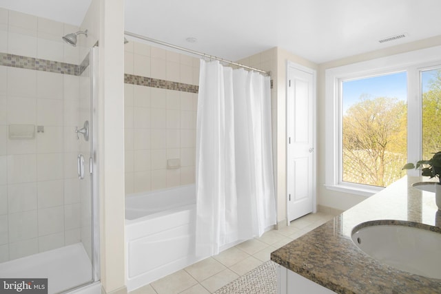 full bath with a sink, double vanity, visible vents, tile patterned flooring, and tiled shower / bath combo