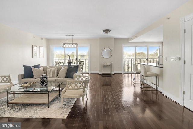living area featuring hardwood / wood-style floors, a healthy amount of sunlight, and baseboards