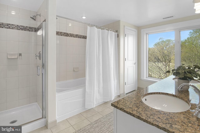 full bath featuring tiled shower / bath, double vanity, tile patterned flooring, and a sink
