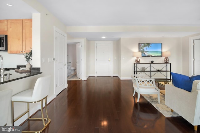 living room featuring dark wood finished floors, baseboards, and recessed lighting