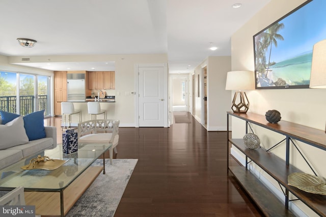 living room with baseboards, wood finished floors, and recessed lighting
