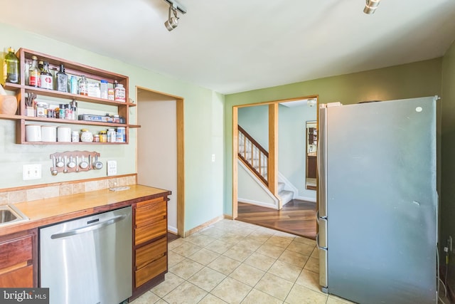 9427 Candleberry Ct, Burke, VA 22015 - kitchen with light tile patterned floors, appliances with stainless steel finishes, light countertops, baseboards, and brown cabinetry