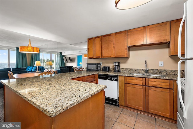 kitchen with a sink, brown cabinets, open floor plan, and white appliances