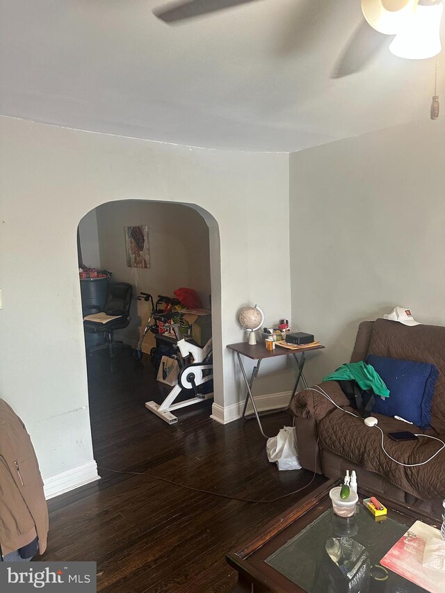 dining area with baseboards, arched walkways, and hardwood / wood-style flooring