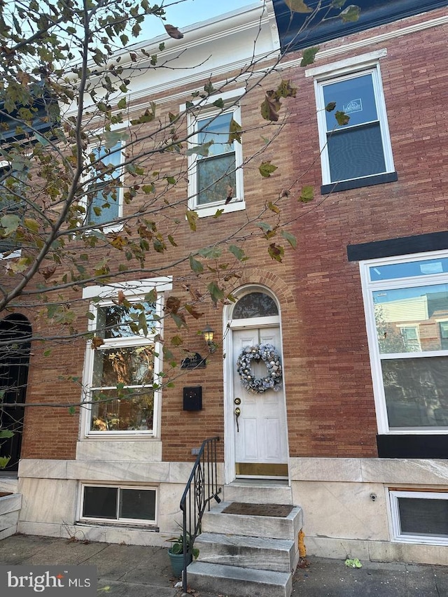 view of front of house featuring entry steps and brick siding