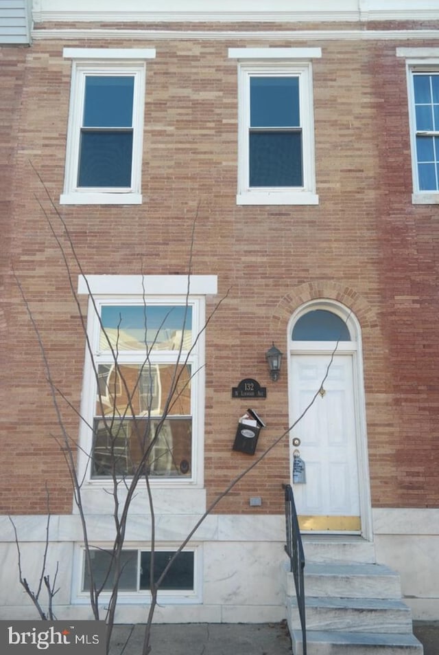 view of front facade featuring brick siding and entry steps