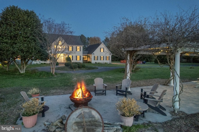 view of community featuring a patio, an outdoor fire pit, and a yard