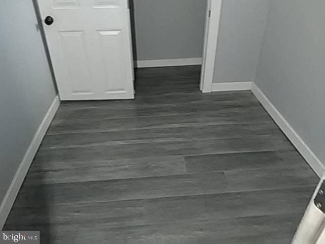 interior space featuring baseboards and dark wood finished floors