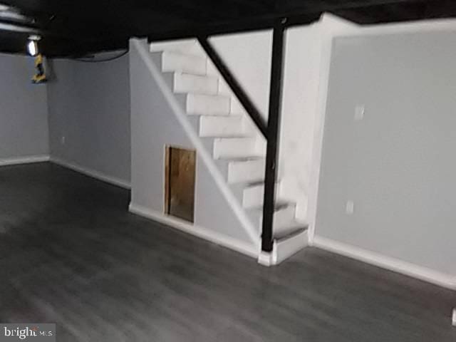 finished basement featuring wood finished floors, stairs, and baseboards