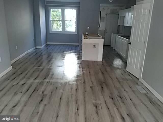 unfurnished dining area featuring baseboards and light wood-style floors