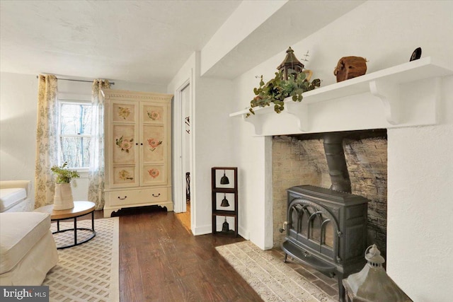 living area with dark wood-type flooring and a wood stove