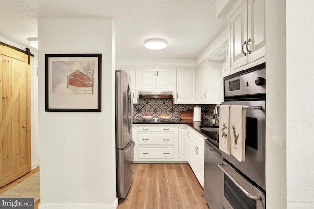 kitchen featuring white cabinets, dark countertops, appliances with stainless steel finishes, and decorative backsplash