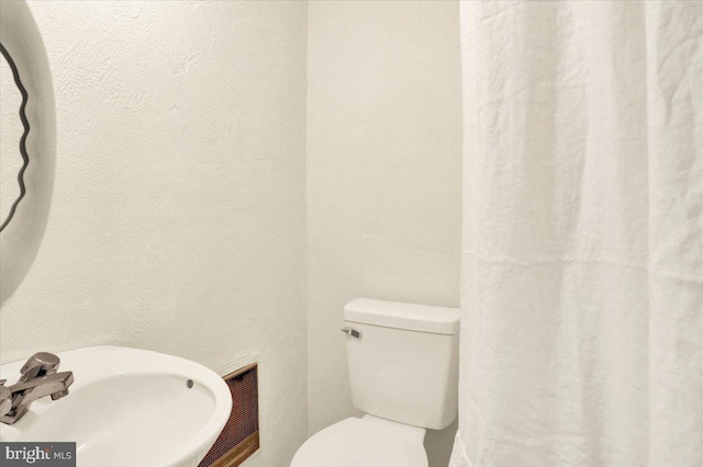 bathroom featuring visible vents, a sink, and toilet