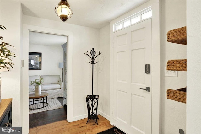 foyer with light wood-type flooring and baseboards