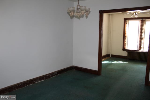 carpeted empty room featuring radiator, baseboards, and ceiling fan with notable chandelier