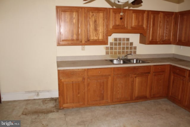 kitchen featuring a sink, ceiling fan, brown cabinets, and light countertops