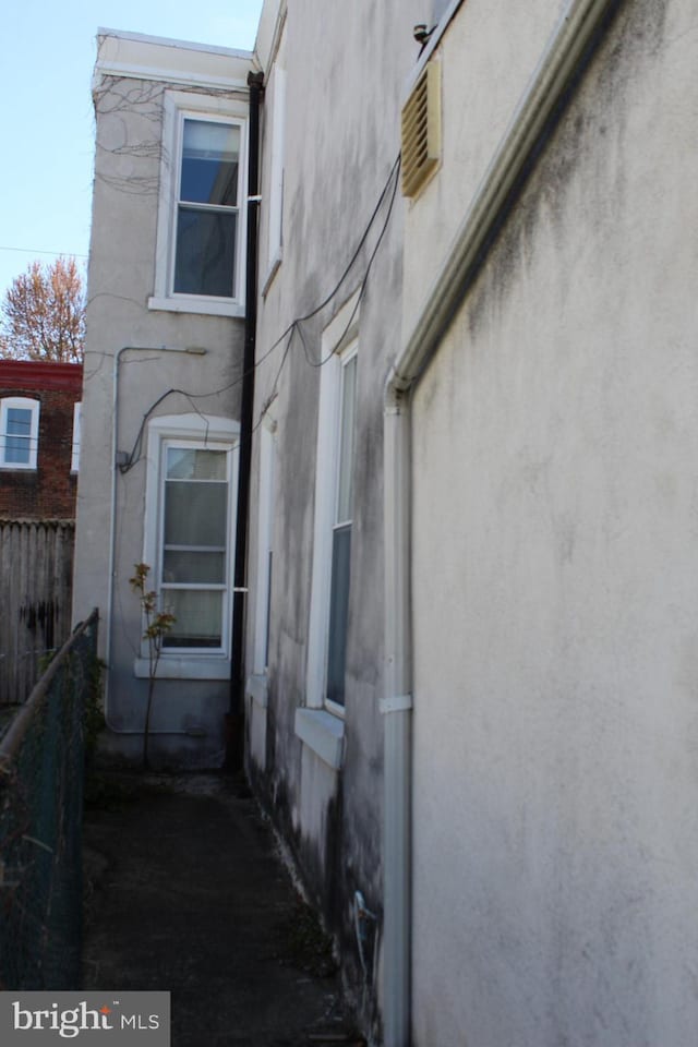 view of property exterior with fence and stucco siding