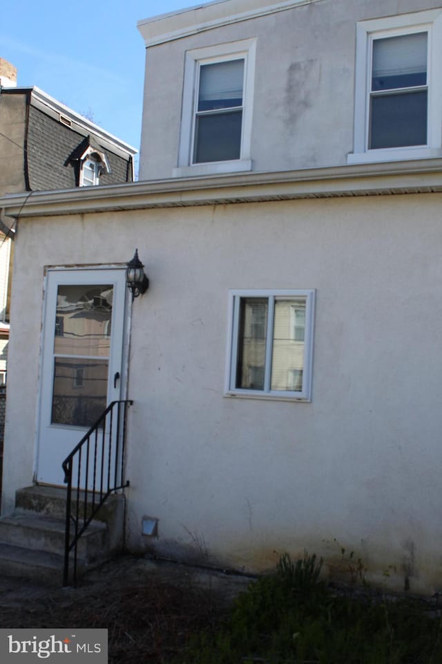 doorway to property featuring stucco siding