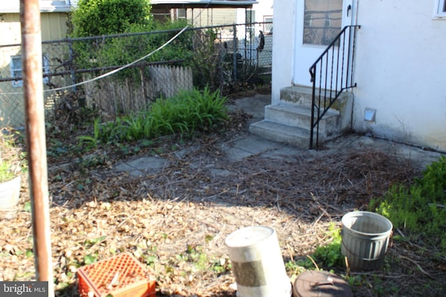 view of yard with entry steps and fence