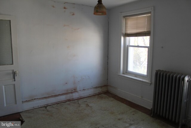 carpeted spare room featuring radiator